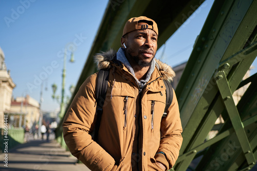 Man in outerwear walking on street photo