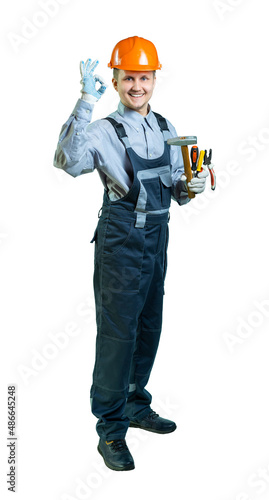 isolated. male engineer, builder in overalls and helmet with a tool in his hands smiles and shows ok © Ольга Новицкая