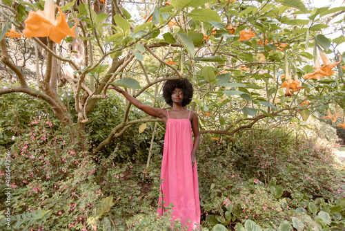 Girl in pink reaches for branch photo