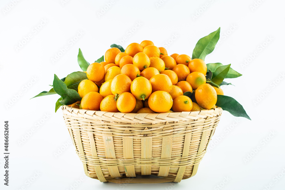 Bamboo basket full of fresh kumquats Bamboo basket full of fresh kumquats