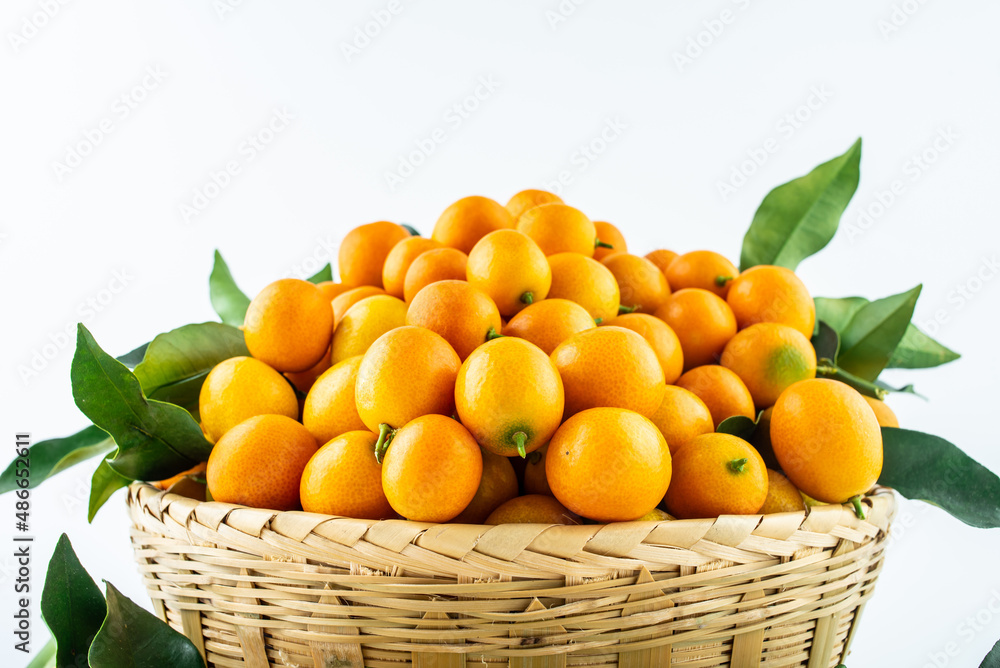 Bamboo basket full of fresh kumquats Bamboo basket full of fresh kumquats