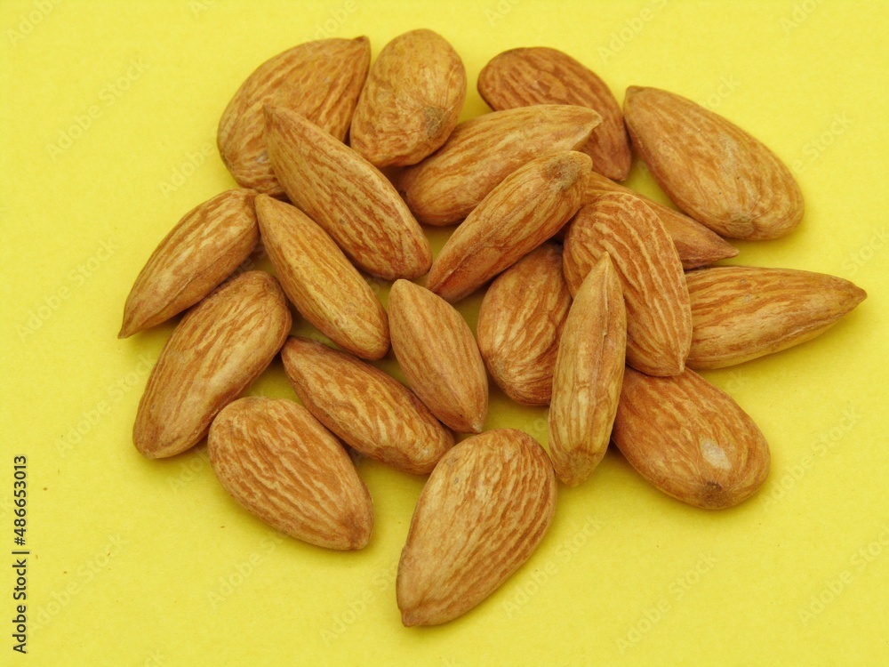 Fototapeta premium Almonds on yellow background