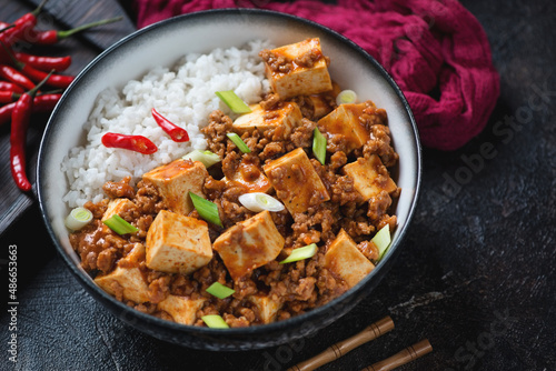 Bowl of mapo tofu or chinese dish made of tofu cubes, ground pork and sichuan peppercorns, middle closeup