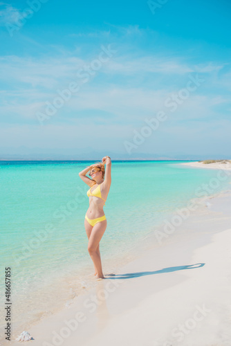  Beautiful plus size young woman on a sand rest at nature at sea, concept of woman's life. Lady L-XL size having fun on a beach