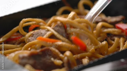 beef with udon noodles in teriyaki sauce close-up. wok noodles