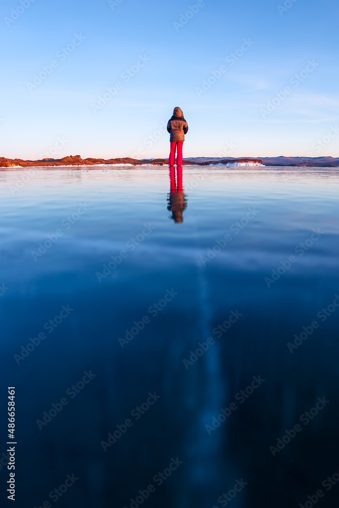 Naklejka premium Girl walking on cracked ice of a frozen lake Baikal