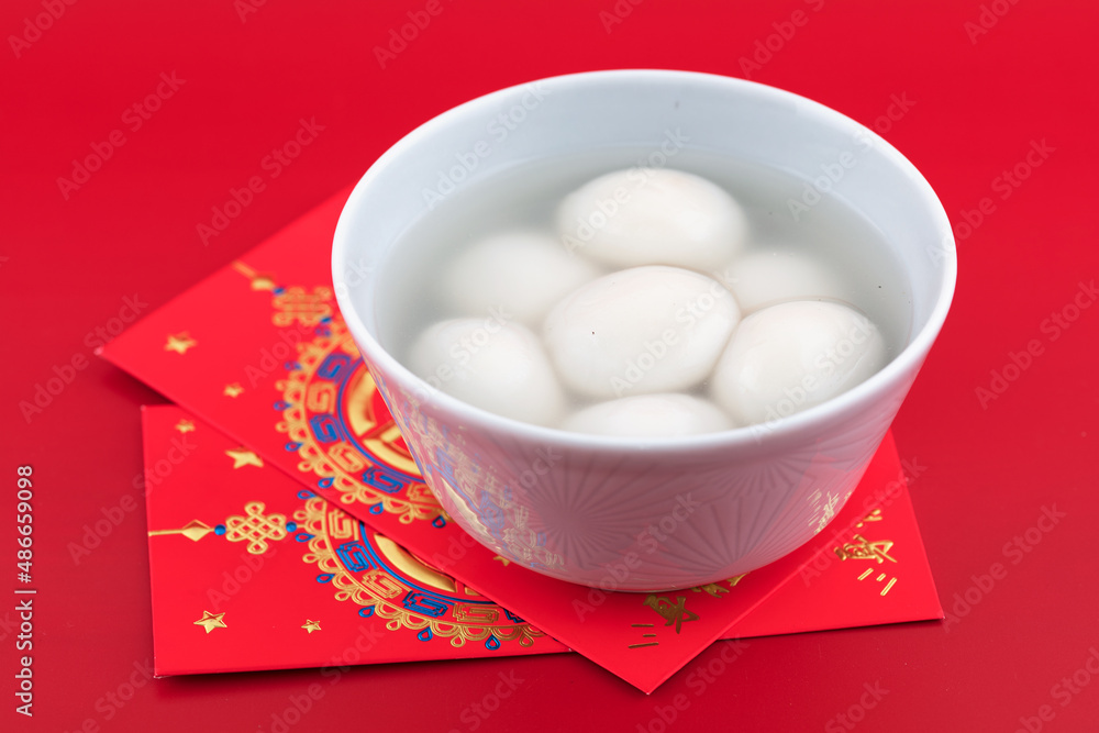 Two bowls of cooked dumplings and red packets Two bowls of cooked dumplings and red packets