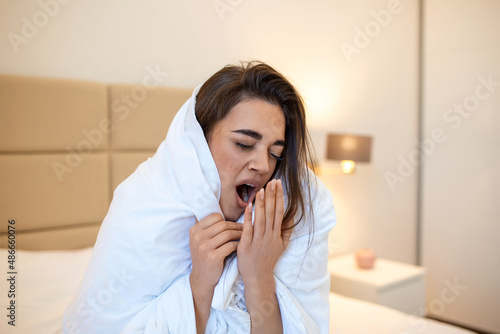 Woman wrapped in a blanket after wake up Yawn , entering a day happy and relaxed after good night sleep. Sweet dreams, good morning, new day, weekend, holidays concept