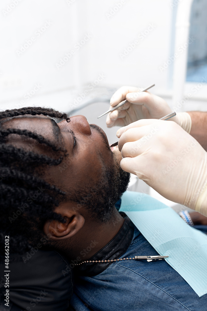 The doctor treats the teeth of a young guy in dentistry. The doctor treats the teeth of a young guy in dentistry.