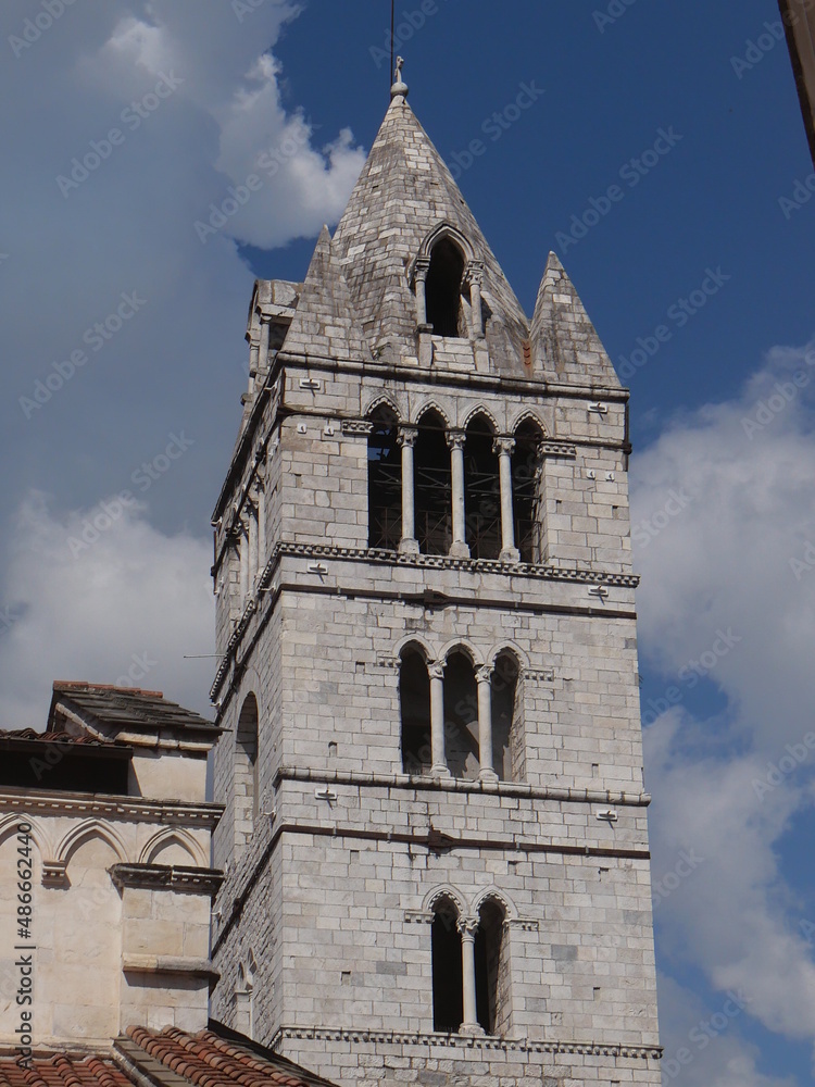 closeup on the bell tower of Cathedral of St Andrew in Carrara in Gothic Romanesque style decorated by marble