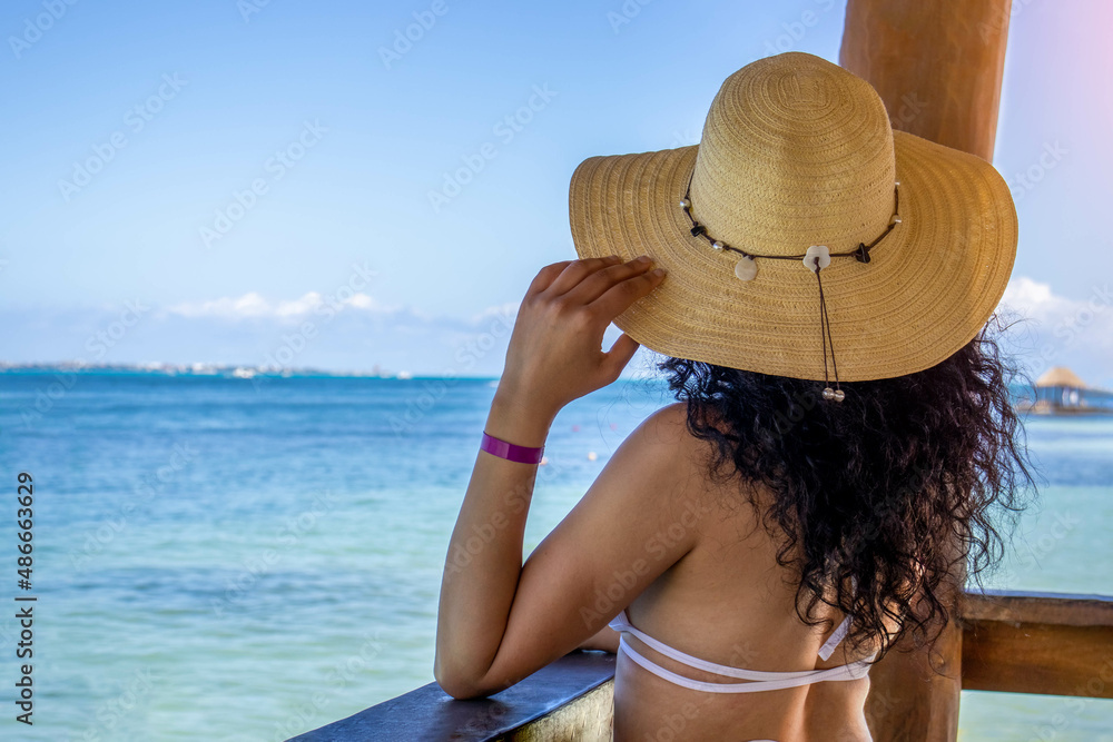 Sexy woman on the beach relaxed and happy enjoying the sunset and in harmony with the caribbean sea.