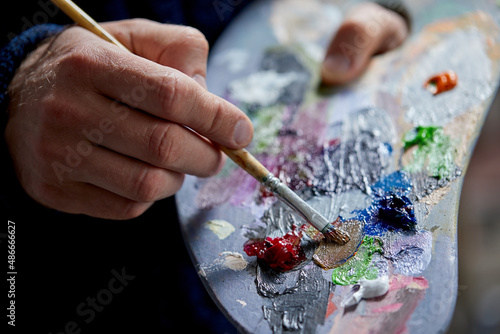 Adult man painter painting on canvas background