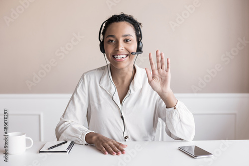 Beautiful business woman looking and speaking through the web camera while making a video conference from office or home photo