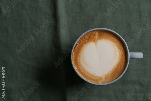 Flat white in white cup with simple latte art on turquoise napkin © GCapture