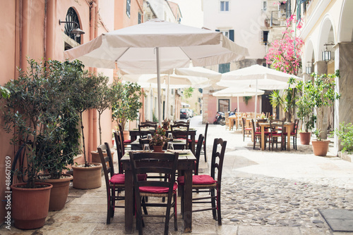 Corfu town beautiful street with cafe tables and flowers, Corfu island, Ionian islands, Greece. Picturesque landmark of Kerkyra old town