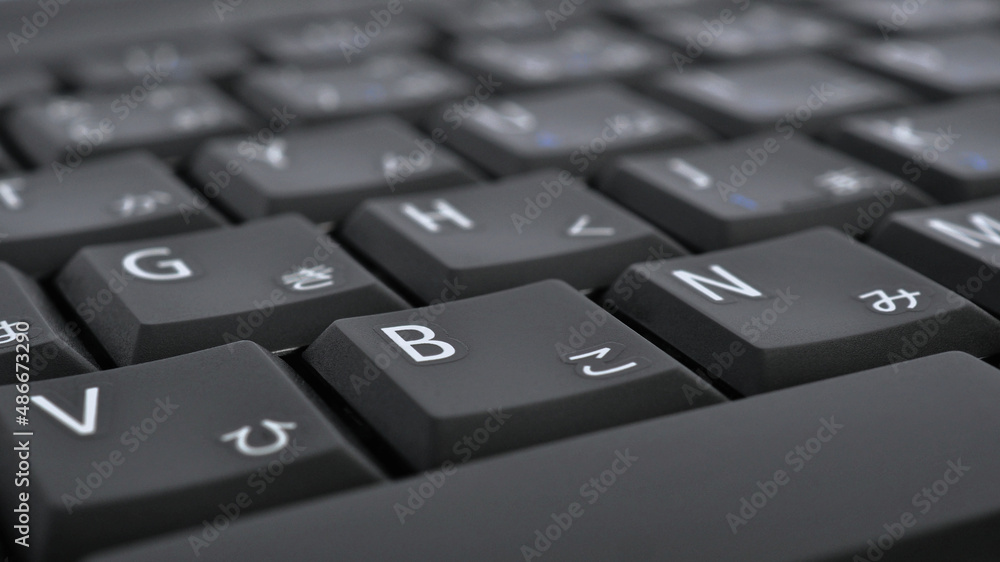 Japanese typing. Black laptop keyboard. Symbols on the buttons of hiragana. Electronic commerce in Japan. IT technologies and data storage. Dark computer background or wallpaper