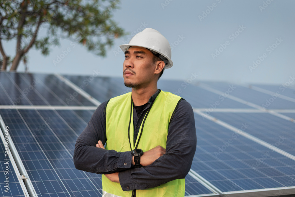 Engineer man standing and crossed arms with solar panels energy. Technician checking and services of photovoltaic solar panels. Sustainable Energy concept. Engineer man standing and crossed arms with solar panels energy. Technician checking and services of photovoltaic solar panels. Sustainable Energy concept.