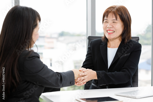 Wallpaper Mural Asian professional successful senior female businesswoman manager in formal suit sitting smiling showing thumb up complimenting happy colleague employee at office working table when job achievement Torontodigital.ca