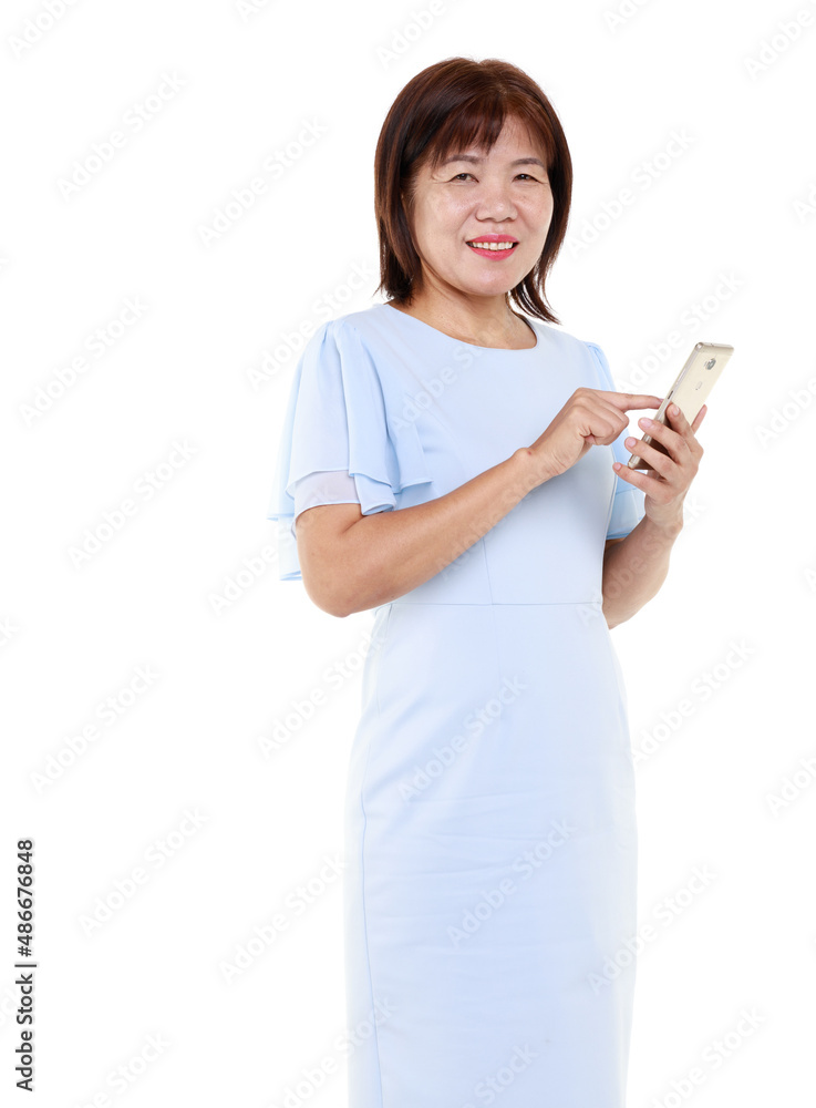 Studio closeup cutout isolated shot of Asian friendly senior grandmother female model in casual outfit standing smiling holding smartphone mobile on white background. Studio closeup cutout isolated shot of Asian friendly senior grandmother female model in casual outfit standing smiling holding smartphone mobile on white background.