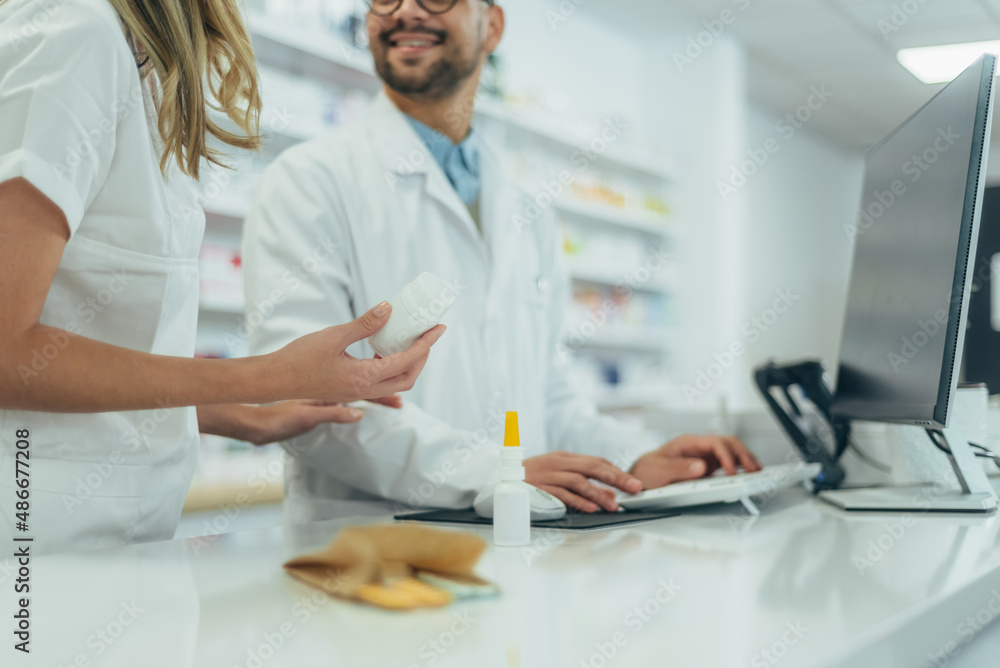 Young female pharmacist holding medications in her hand Young female pharmacist holding medications in her hand