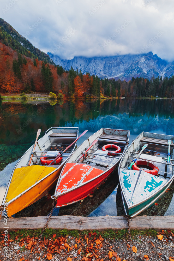 Beautiful Fusine lake in nice autumn colors in the background with the Mangart mountains at sunset, near Slovenia