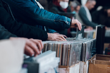 Fotobehang Muziekwinkel Man bladert door vinylalbums in platenzaak  © Zamrznuti tonovi