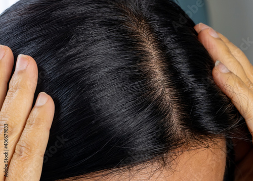 Closeup Asian woman head, natural healthy clean dark strong hair no dandruff. 