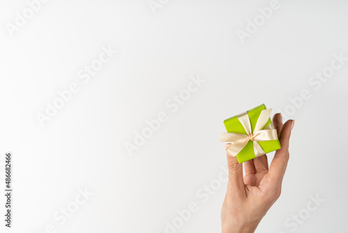 Flatlay, top view, white background, small gift boxes and a woman's hand