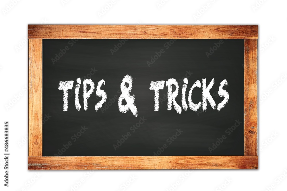 Fototapeta premium TIPS & TRICKS text written on wooden frame school blackboard.