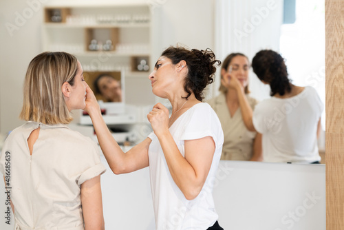 Schilderij op canvas Cosmetologist doing beauty procedure on face of client