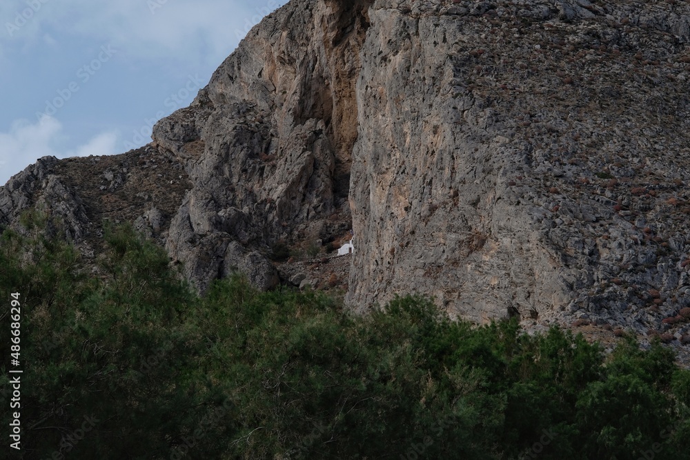 View of a small white chapel build inside a mountain near Perissa in Santorini Greece