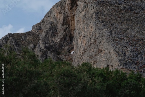 View of a small white chapel build inside a mountain near Perissa in Santorini Greece