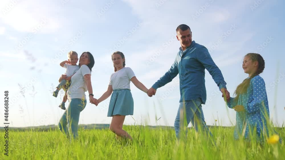 people in the park. happy family walk in the park on green grass in nature. mom father and children walk sunlight in nature summer. outdoor picnic relaxing in forest park. friendly family together people in the park. happy family walk in the park on green grass in nature. mom father and children walk sunlight in nature summer. outdoor picnic relaxing in forest park. friendly family together