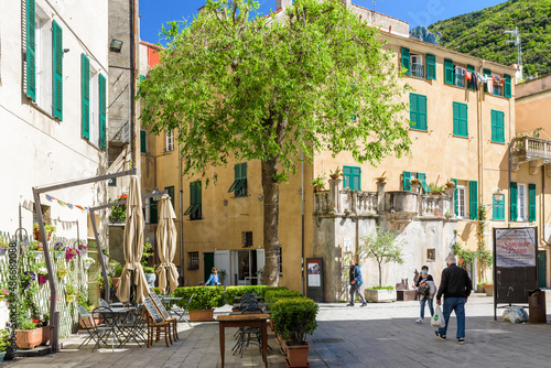 Finalborgo, Finale Ligure, Italy. May 5, 2021. View of Via Lancellotto with outdoor tables of a restaurant.