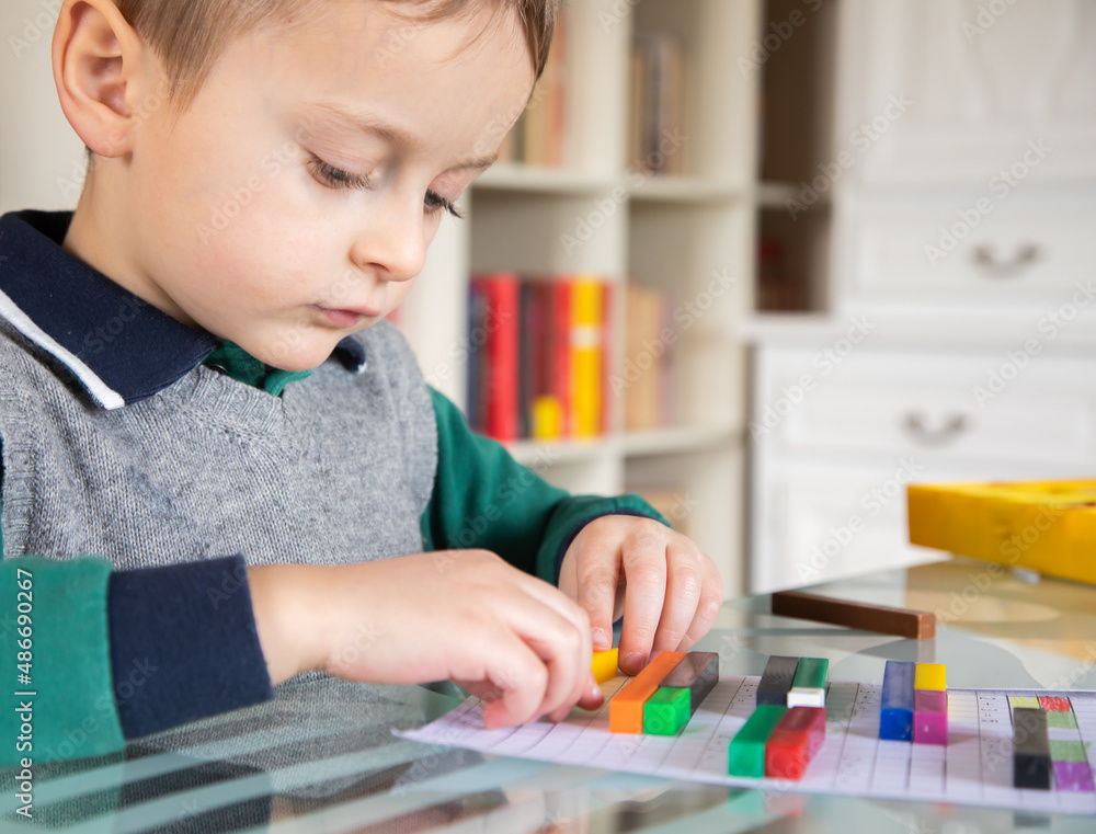 6 years old caucasian boy learning at home mathematics. Elementary age. 6 years old caucasian boy learning at home mathematics. Elementary age.