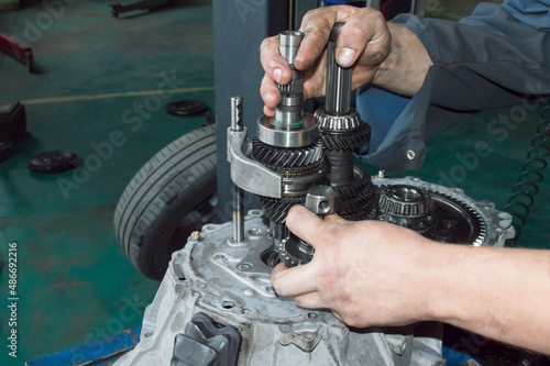 The mechanic installs the intermediate gear of the rear gear of the manual transmission