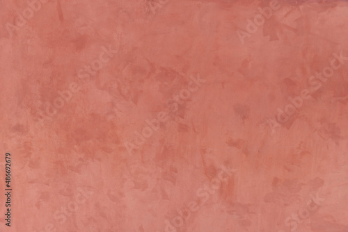 Decorative wall pastel color stucco background. Peach color painted background. Textured terracotta wall with space for text. Abstract soft backdrop. Copy space. Close up house wall in Santorini