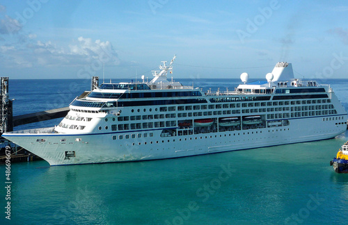 Small classic Oceania cruiseship or cruise ship liner Regatta in Port of Barbados with horizon in background waiting for passengers for Caribbean cruising holiday	 photo