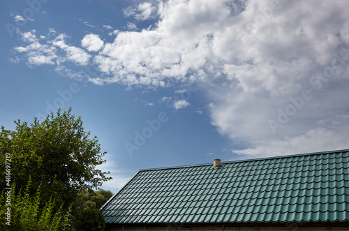 Construction of the roof of the house. Metal tiles against blue sky