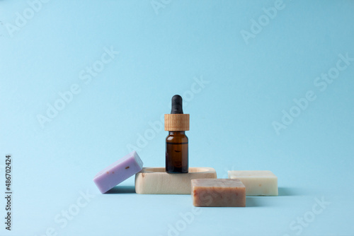 Cosmetic bottle with soap on blue background. Close up, copy space