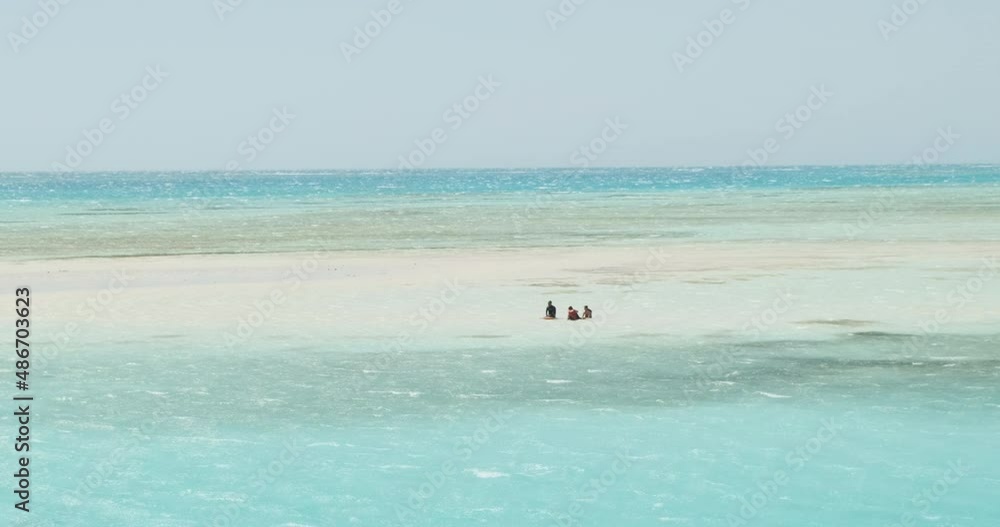 Tourists sitting in the water on the White Island of Ras Mohamed, among the very beautiful turquoise water, in the middle of the red sea. Clear day, small waves. Wide shot, slow motion. Tourists sitting in the water on the White Island of Ras Mohamed, among the very beautiful turquoise water, in the middle of the red sea. Clear day, small waves. Wide shot, slow motion.