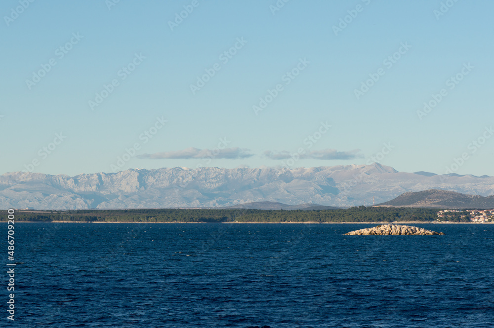 Scenic view from the sea on the Croatian coastline and Velebit mountains, near Pakostane in Dalmatia