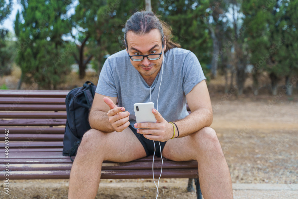 Man in shock looking at his smartphone Man in shock looking at his smartphone