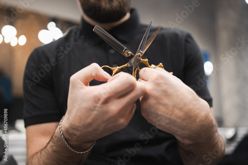 Male hairdresser holding professional scissors at barbershop © Andrii 