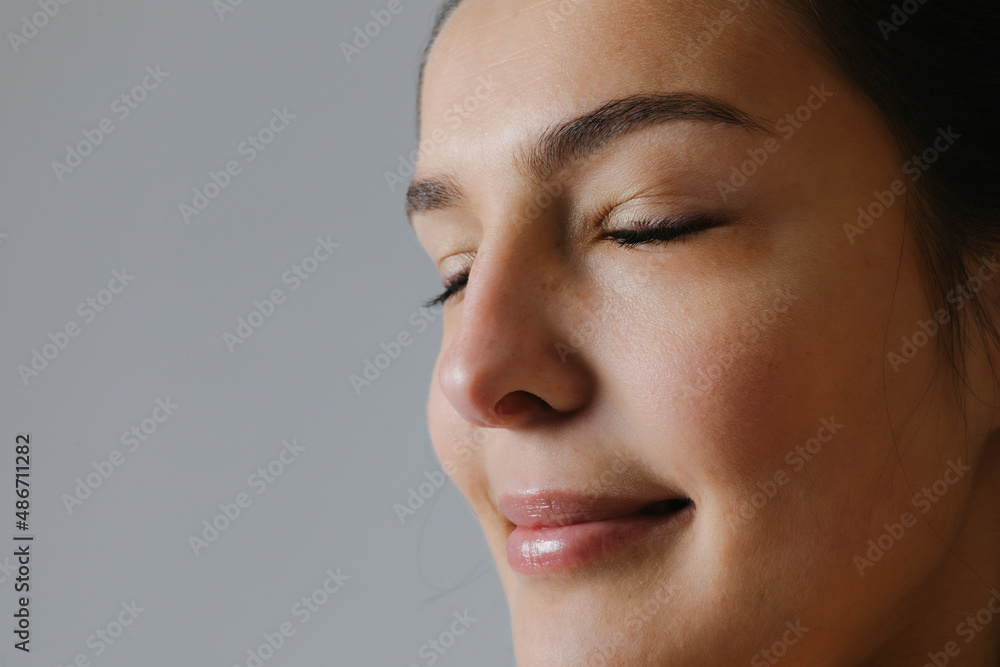 Close-up portrait of woman with closed eyes practicing meditation in the studio. Close-up portrait of woman with closed eyes practicing meditation in the studio.