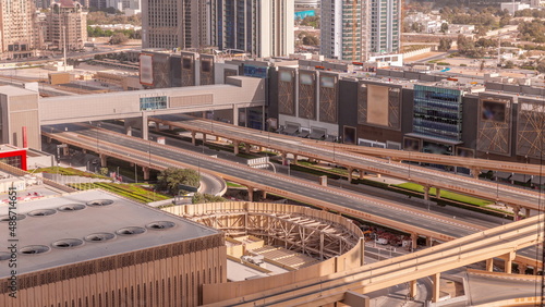 Highway road traffic on overpass under footbridge near shopping mall in Dubai downtown timelapse