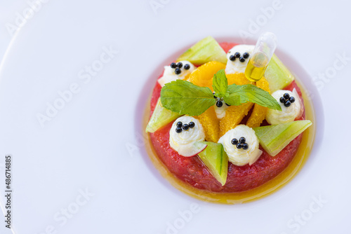Tropical fruit salad with dragon fruit, watermelon and orange papaya on white elegant background. Healthy diet, breakfast in luxury resort hotel. Gourmet vegan fruits
