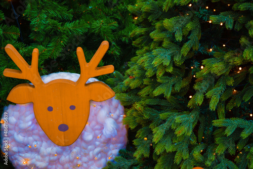 wooden glowing fawn on the background of the Christmas tree