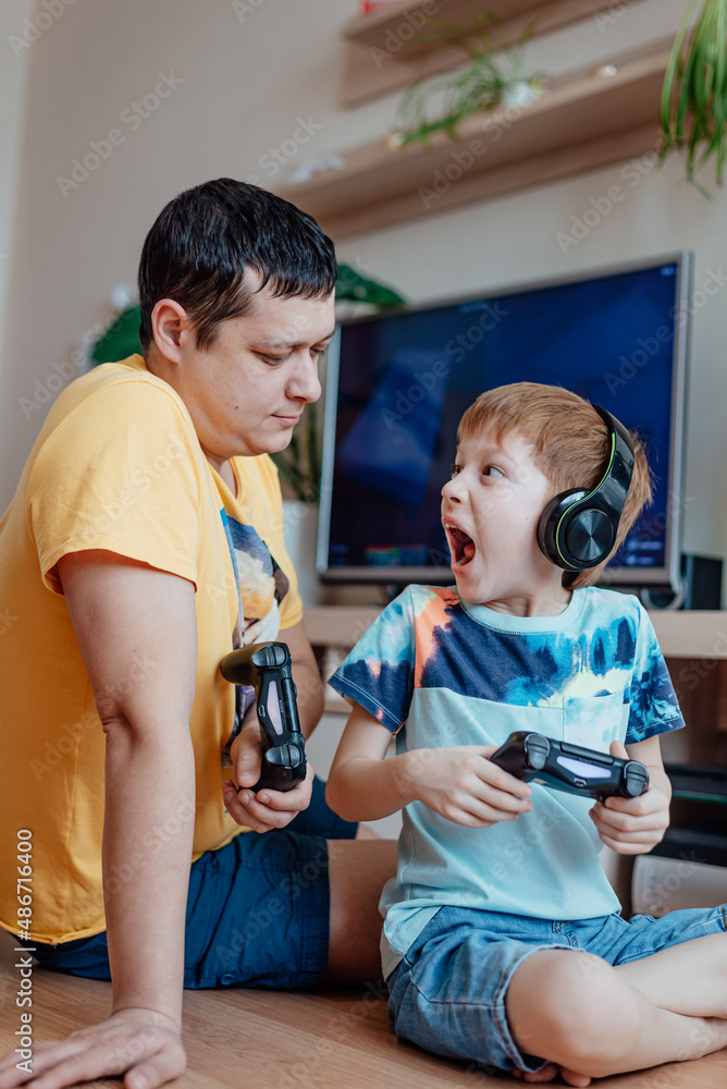 Family leisure father and son play video games, child redhead boy screaming lose Family leisure father and son play video games, child redhead boy screaming lose
