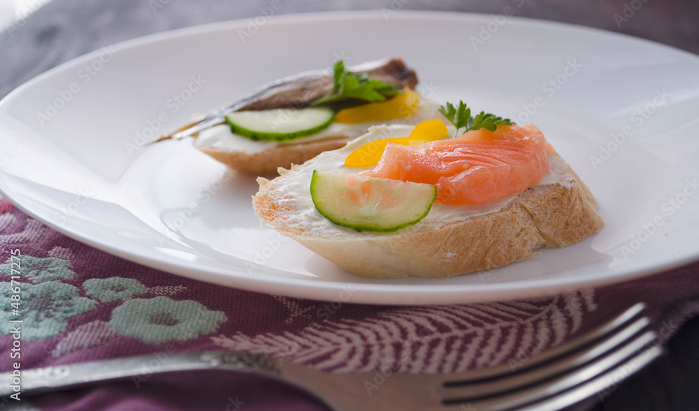Sandwich, sandwich with salmon and sprats on a plate. Macro background. High quality photo. Banquet. Sandwich, sandwich with salmon and sprats on a plate. Macro background. High quality photo. Banquet.